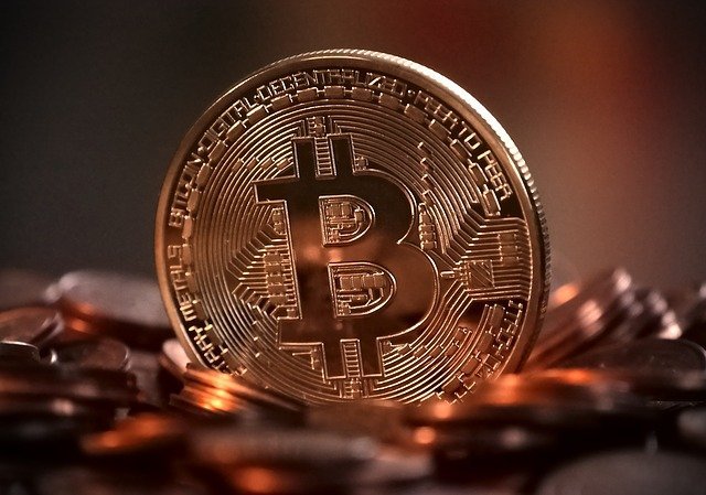 Bitcoin in the form of a physical coin on top of other coins
